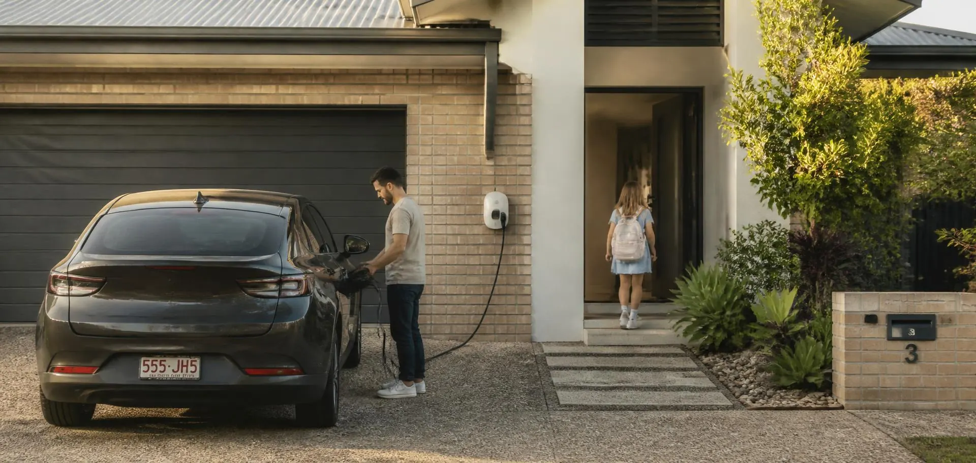 Family arriving home at a Newcastle house in the late afternoon and plugging in their electric car